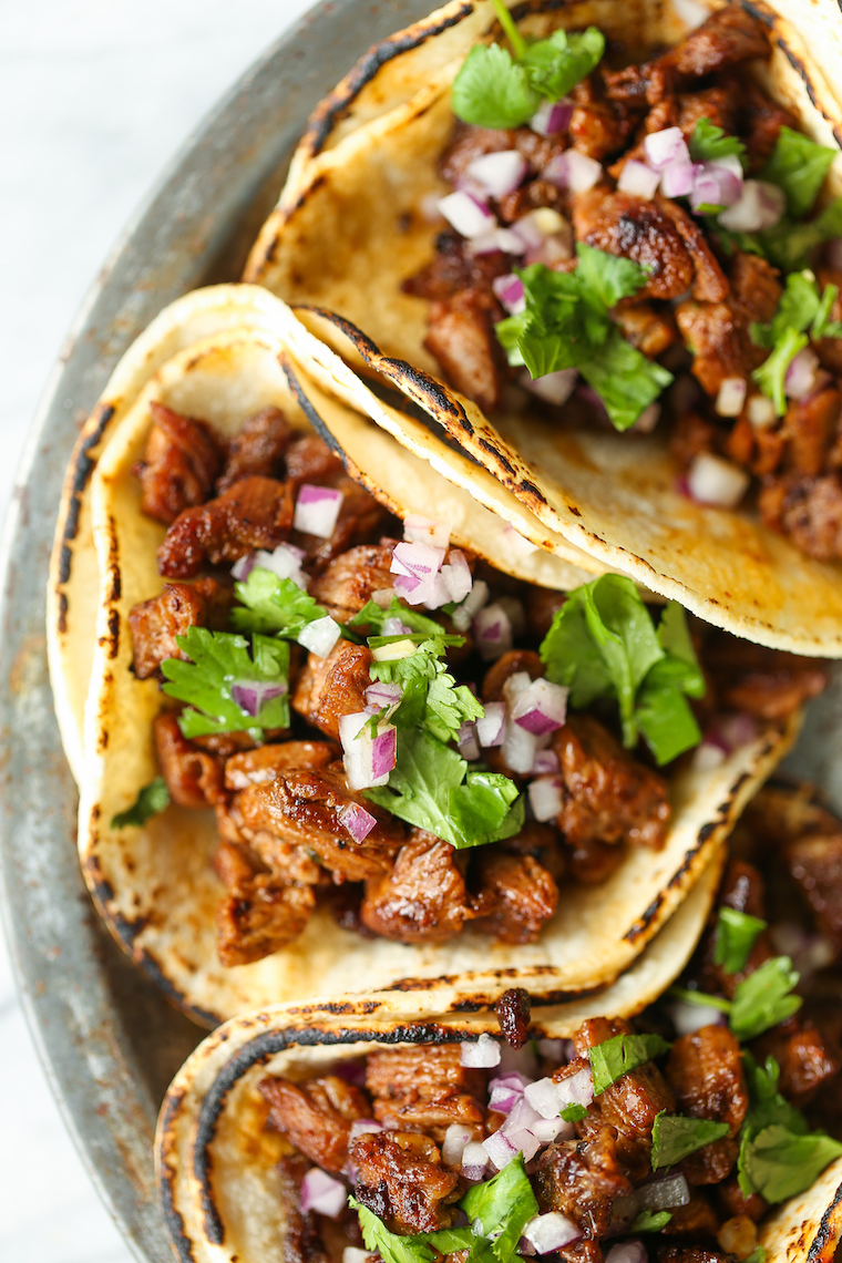 Street tacos topped with chopped onions and fresh cilantro
